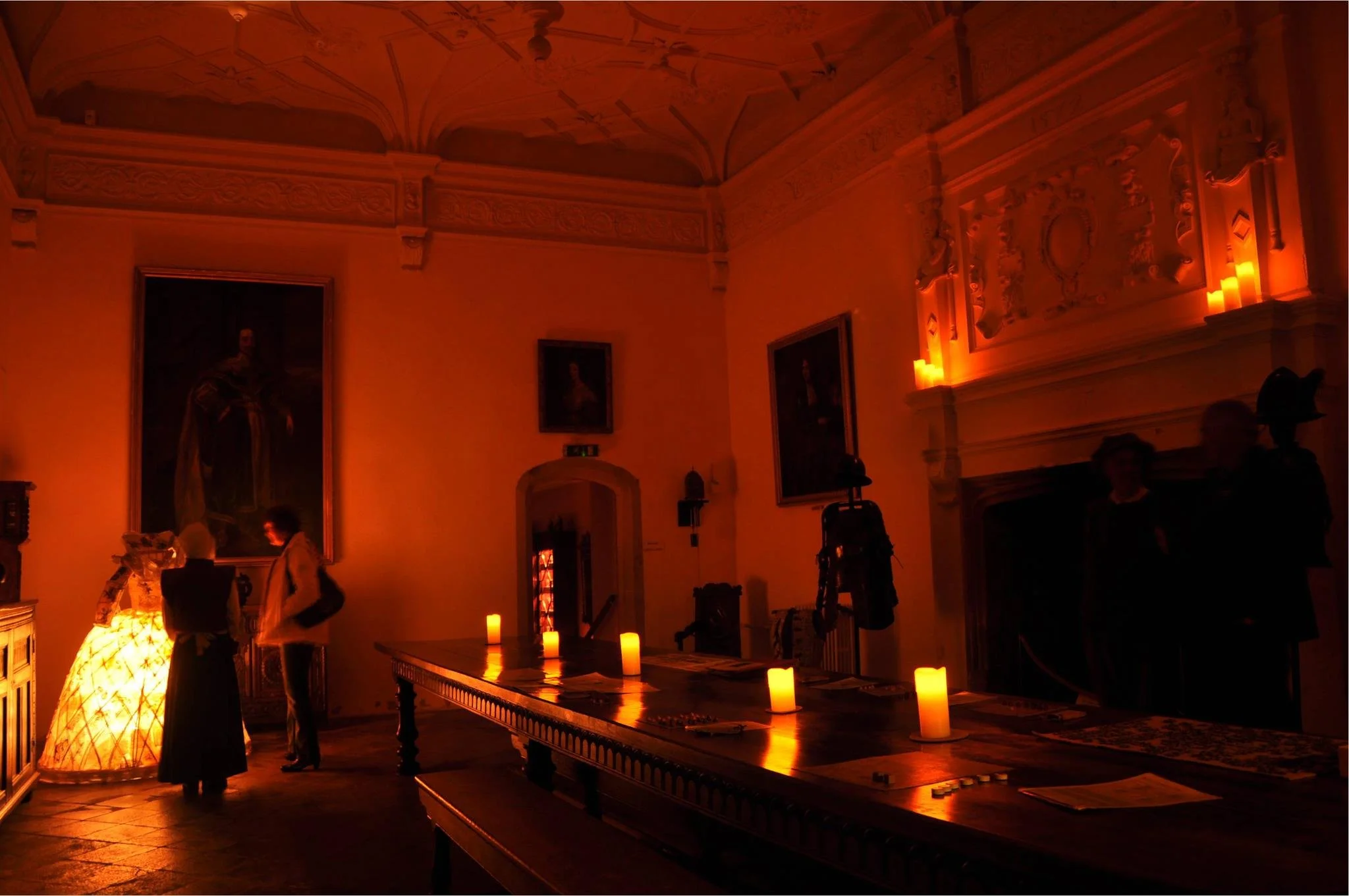 Candlelit night-time event inside a historic National Trust house, with visitors exploring a sensory interpretation experience.