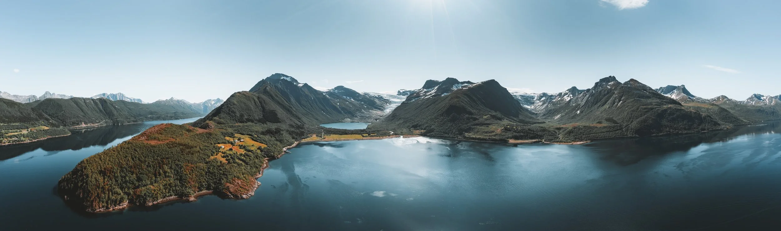 Aerial panoramic view near Briksdal Glacier in Norway, with mountains, blue water and glacier landscape.