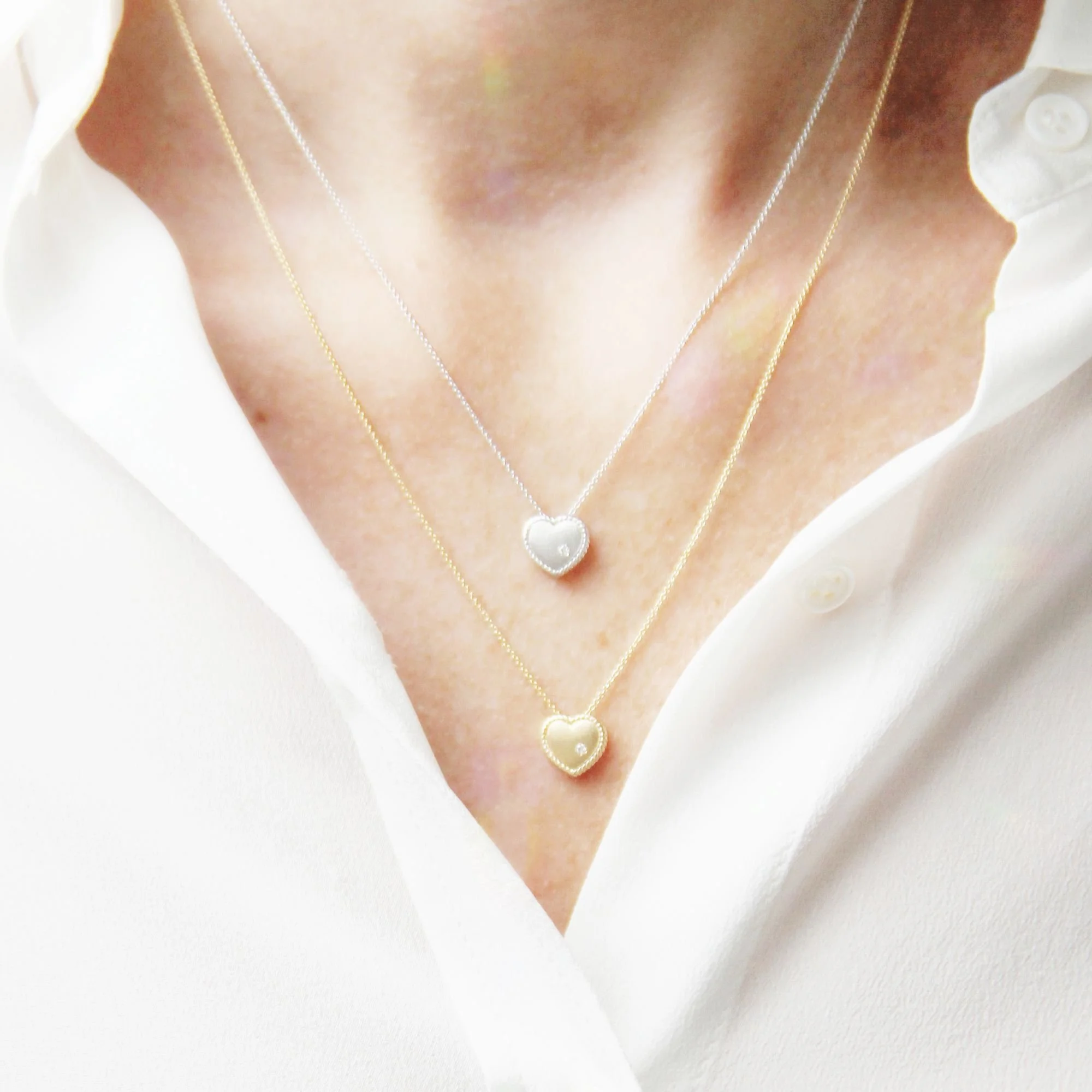 14ct yellow and white gold heart and diamond necklaces being worn.