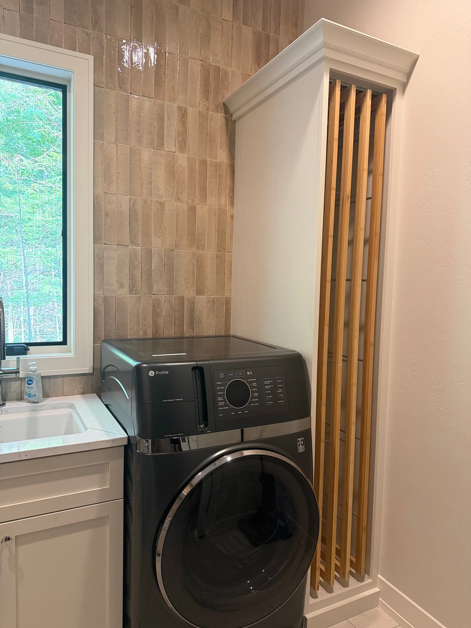 Laundry room with tile backsplash in new home