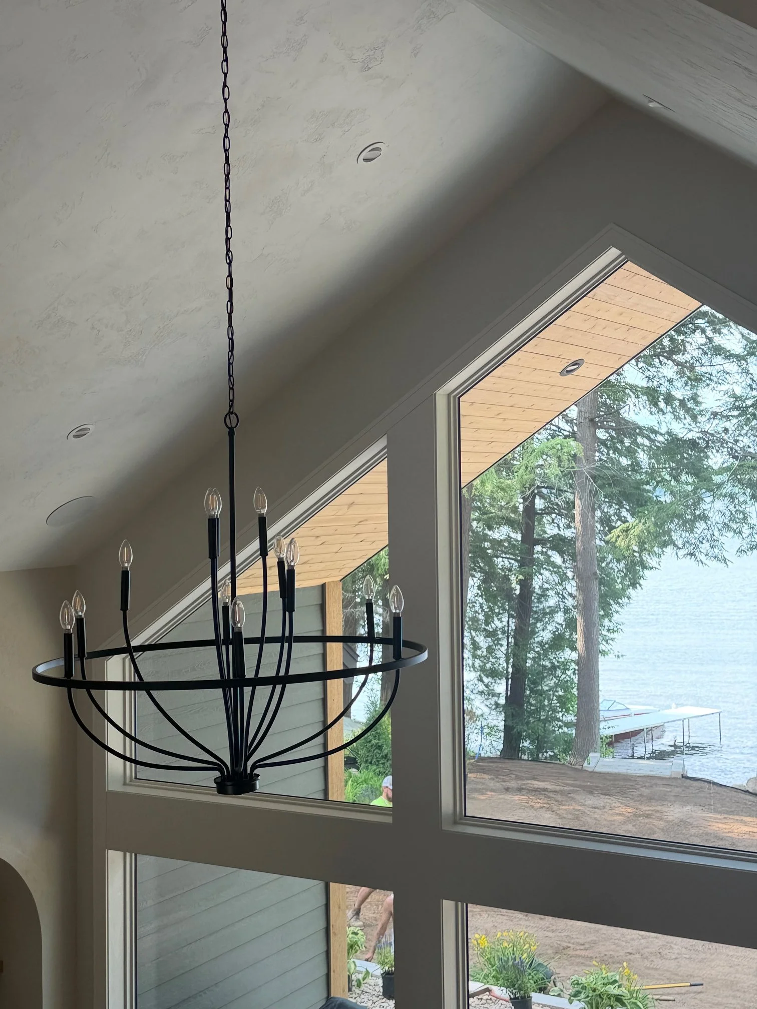 Chandelier beneath gable window with lake view