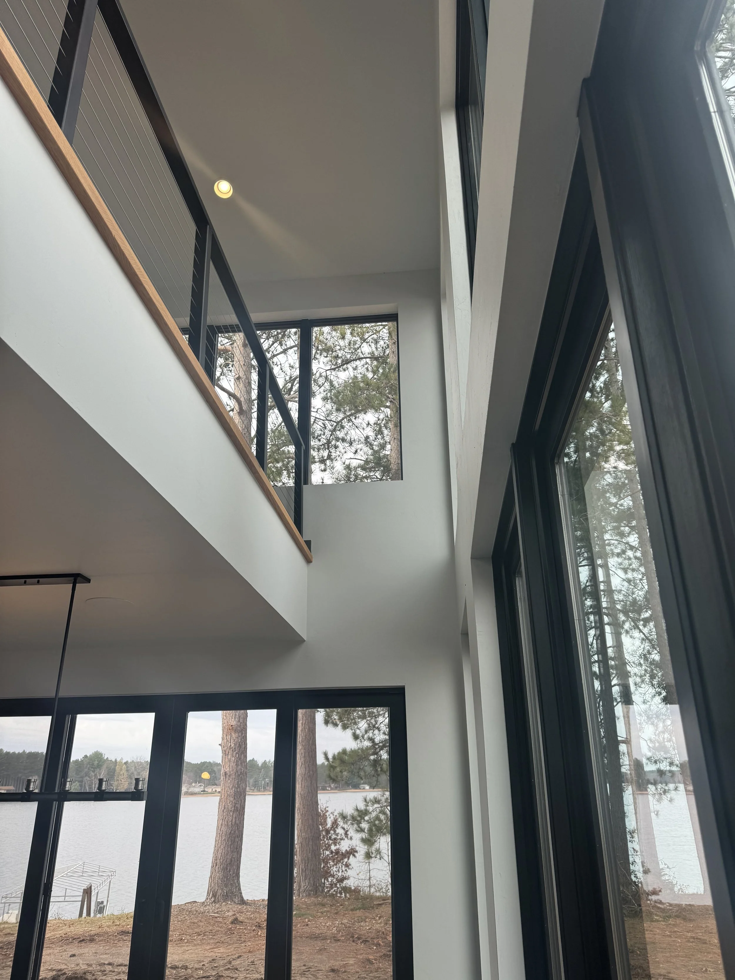 Large black windows in a new home with a view of a lake