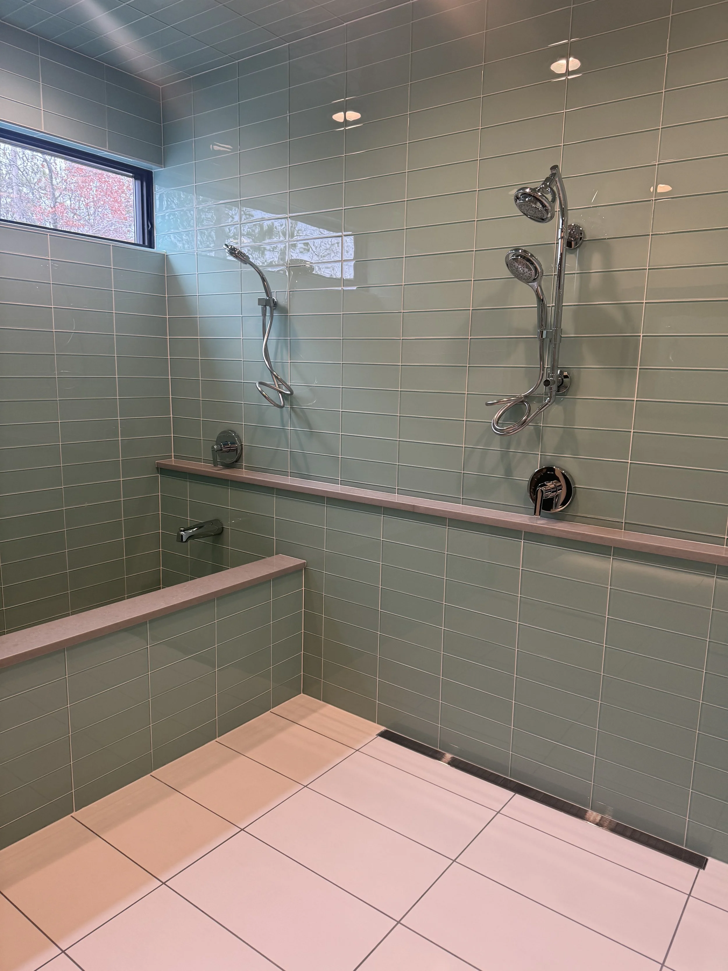 Walk-in shower and tub with green tiles