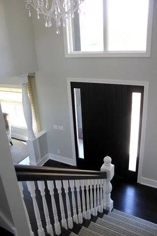 Large foyer with black and white stairs