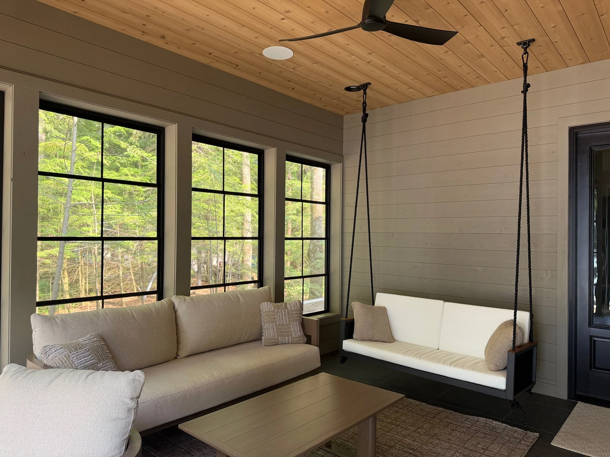 Screened porch swing and sofa overlooking the lake
