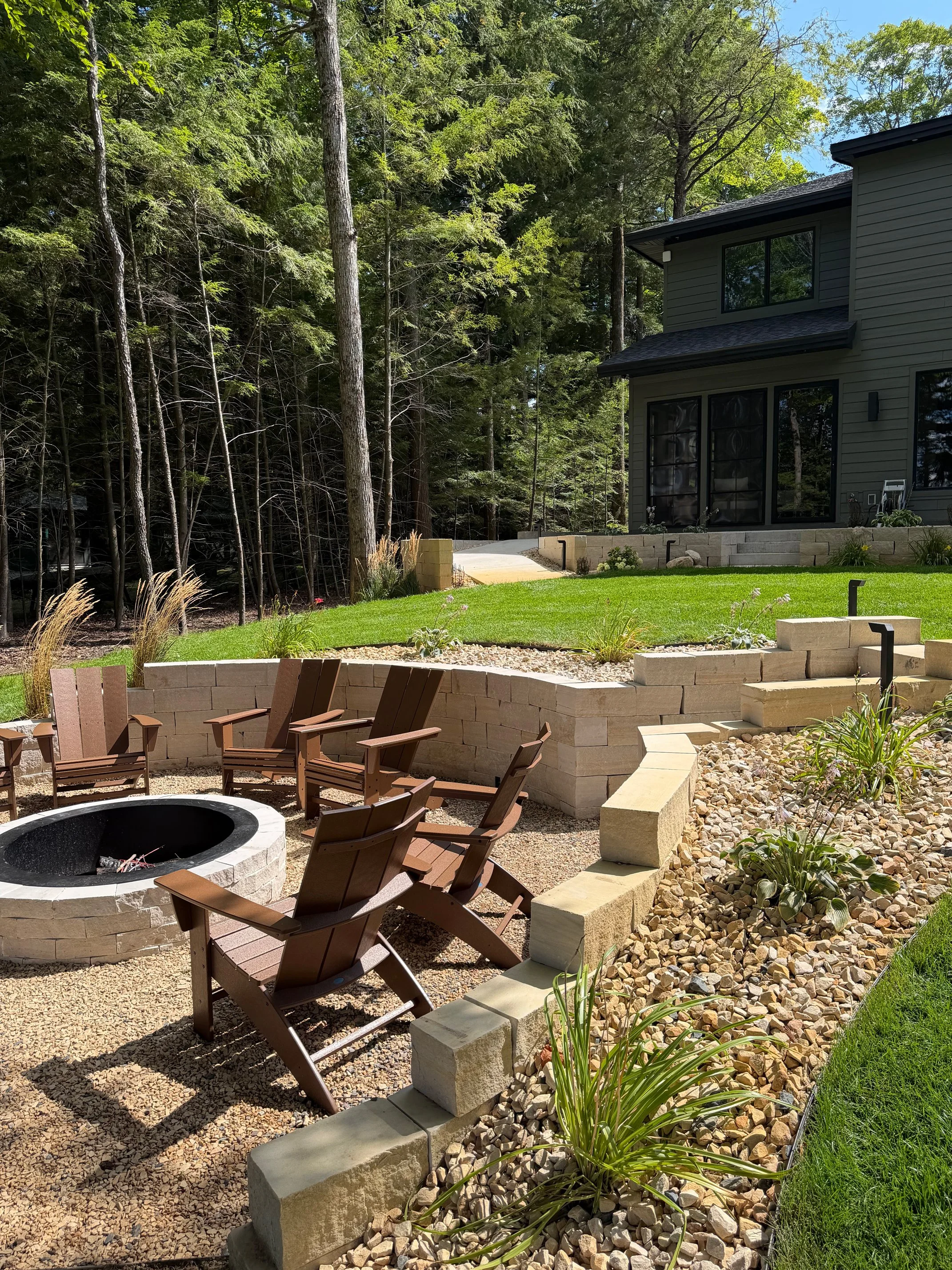 Fire pit patio with Adirondack chairs at luxury home