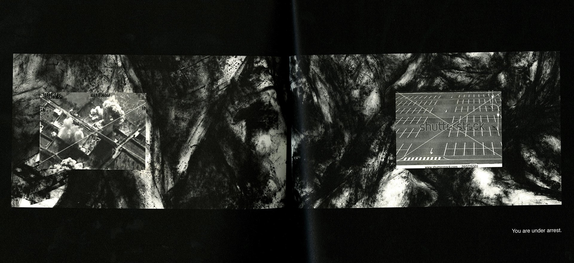 Alt Text: Interior spread view. Spread bracketed by two black bars on upper and lower portions of book. Thick, black ink washes take up entire spread. Visible over this, one on each page are two, small images. One, an aerial view of an airstrike, the
