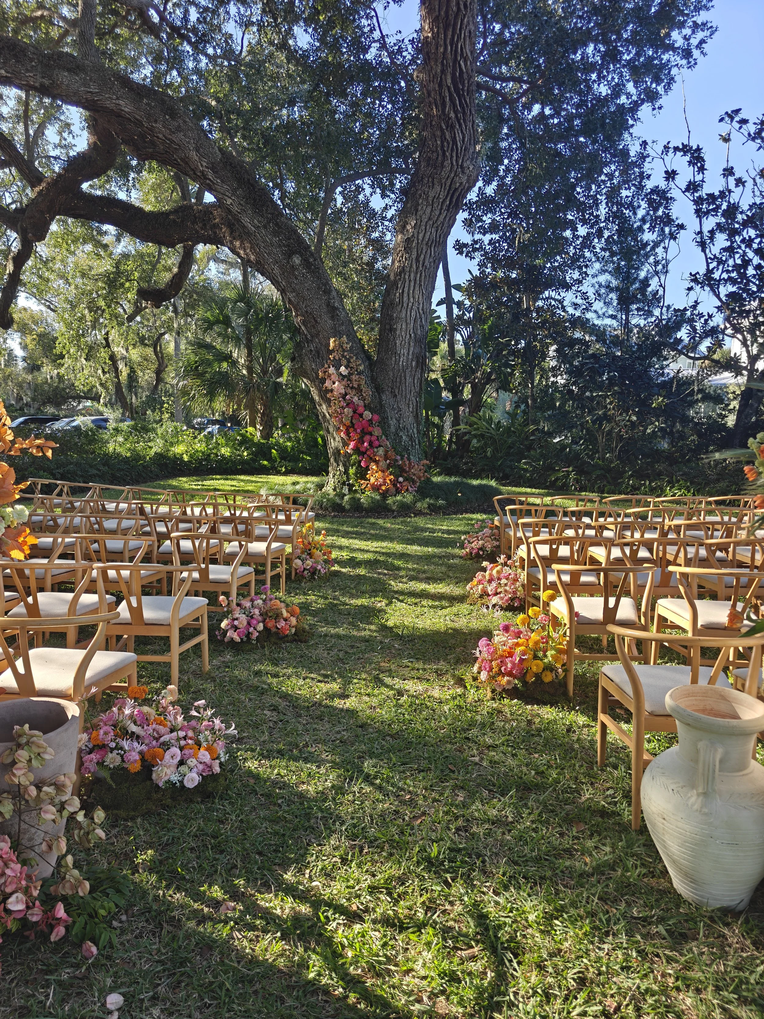 East Garden outdoor ceremony space at Victoria 1883 in New Smyrna Beach Florida beneath 500-year-old live oak trees with river views