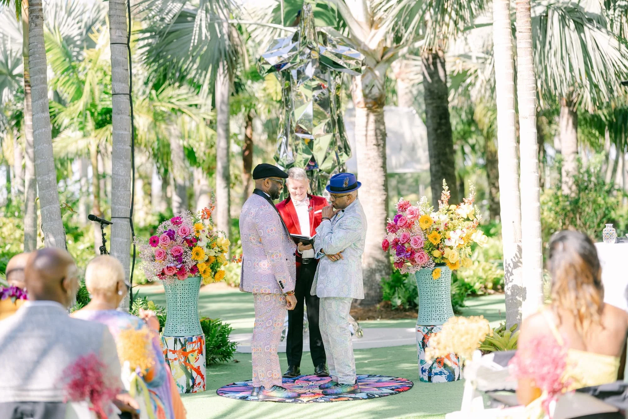 Guy Swenson of Guy Thee Wed officiating a vibrant and colorful African American gay wedding ceremony in the Sculpture Garden at Lake Nona Wave Hotel.
