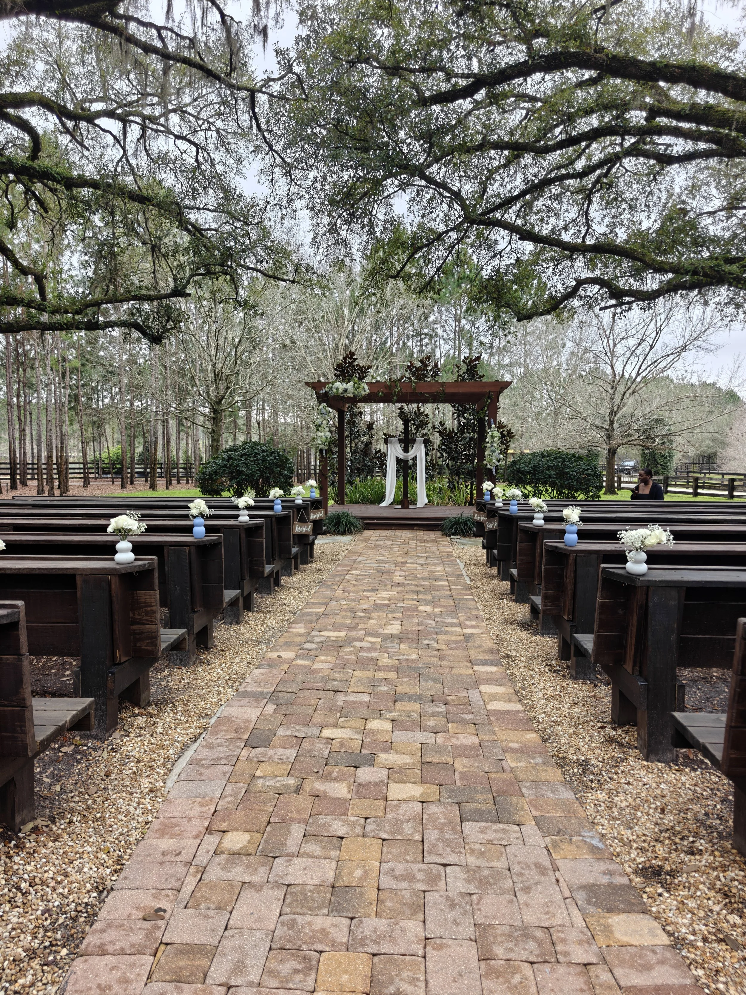 Outdoor ceremony space at Club Lake Venue in Apopka Florida with wooden pergola beneath 100-year-old live oak canopy and two lakes in background
