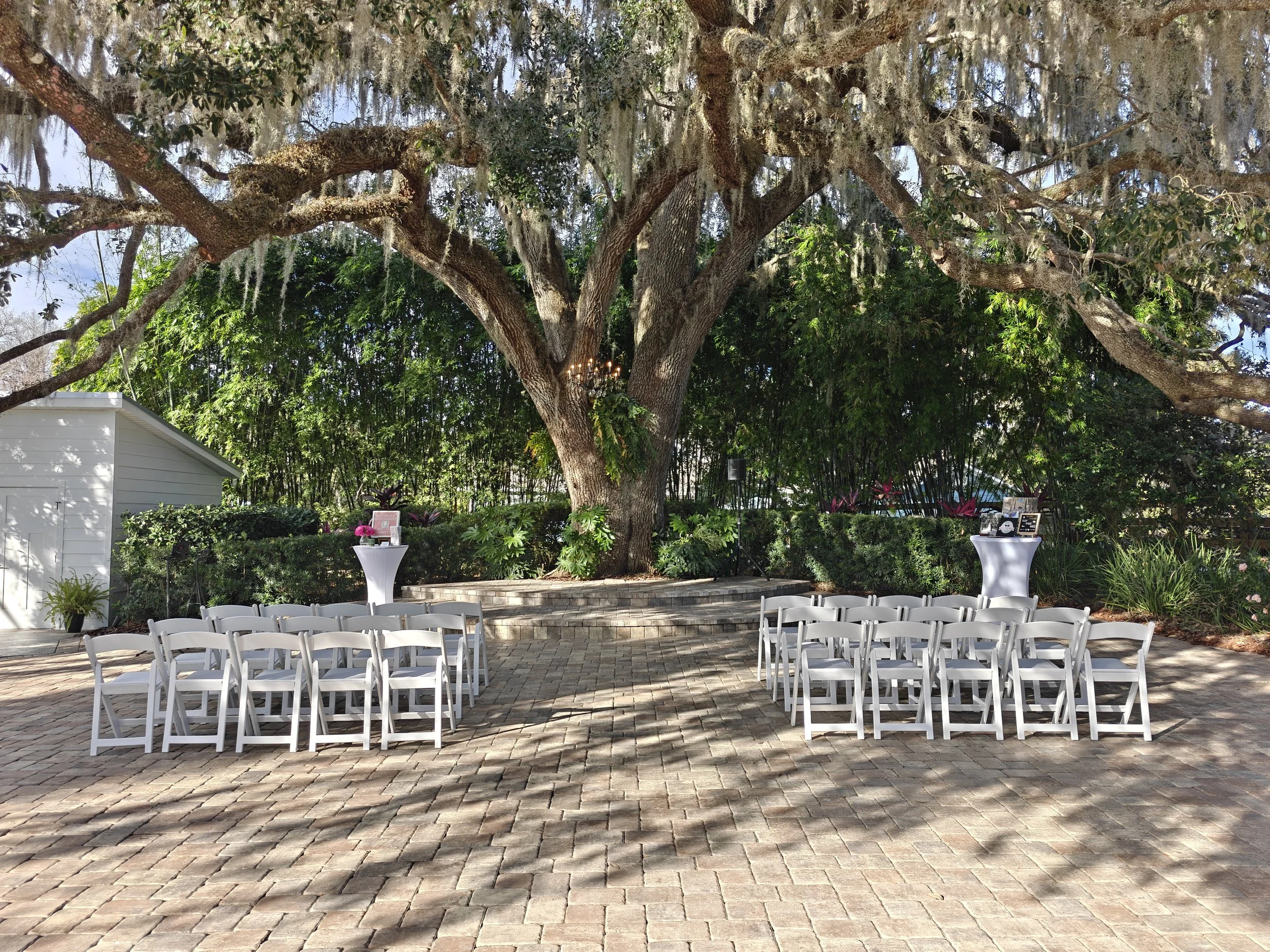 Outdoor ceremony space at Moss Estates in Eustis Florida beneath 150-year-old oak tree with vintage double doors and paved aisle