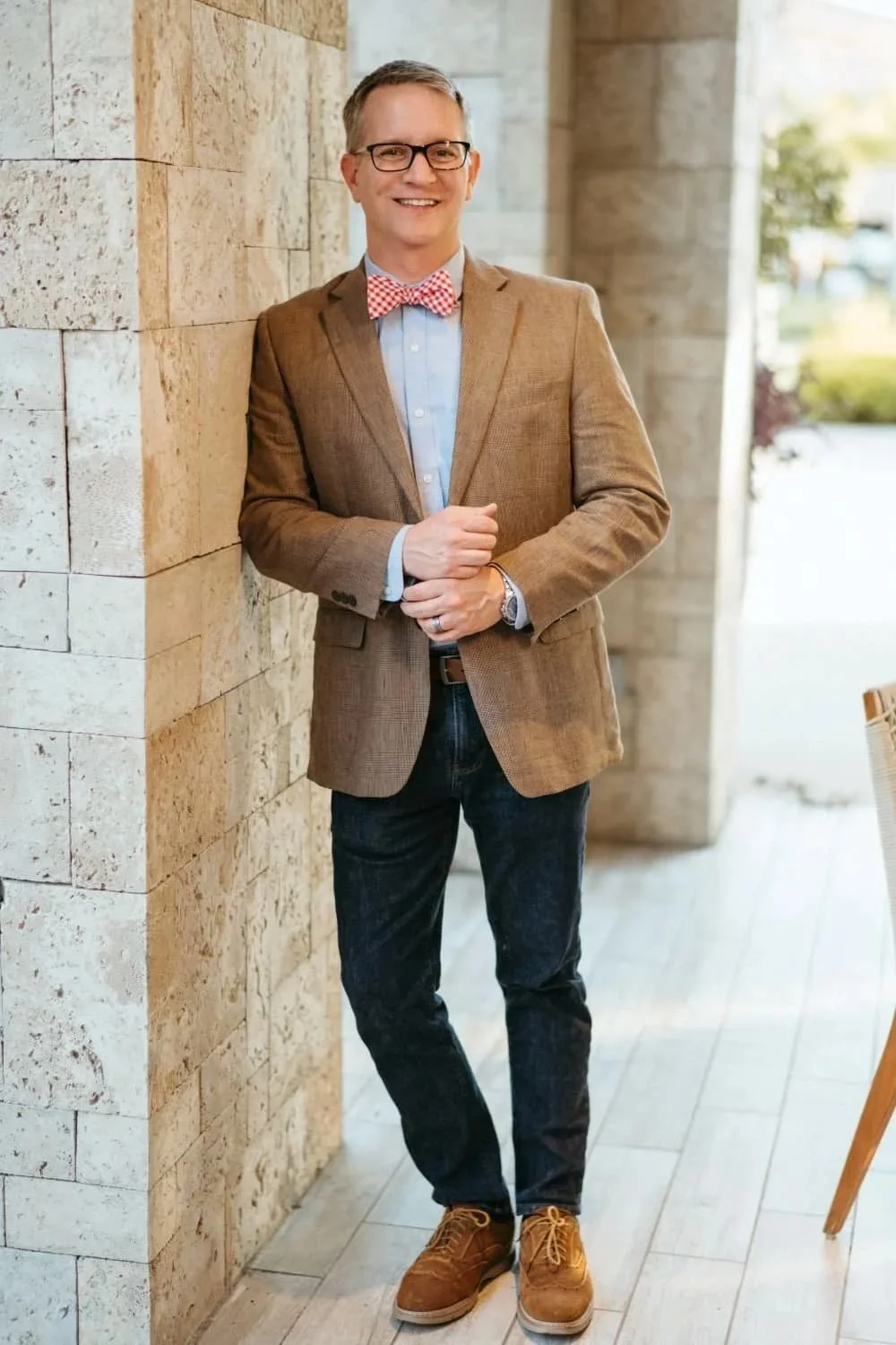 Guy is looking dapper in his jacket and colorful bowtie
