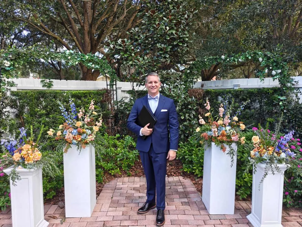 Guy is wearing a blue suit with a bowtie waiting for a wedding to begin in Sanford, Florida