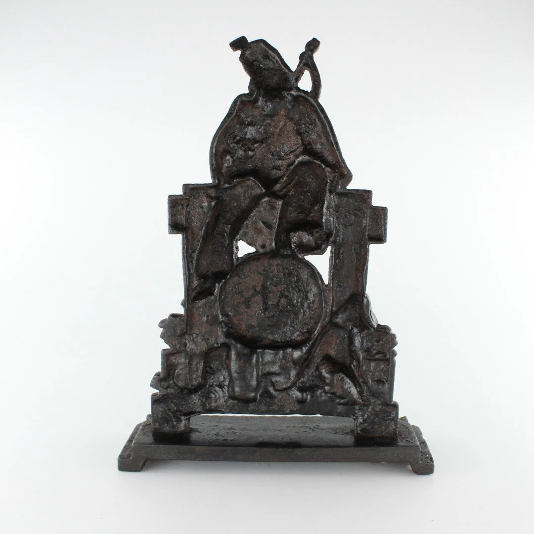 Vintage cast iron figural doorstop depicting seated scholar with decorative relief base