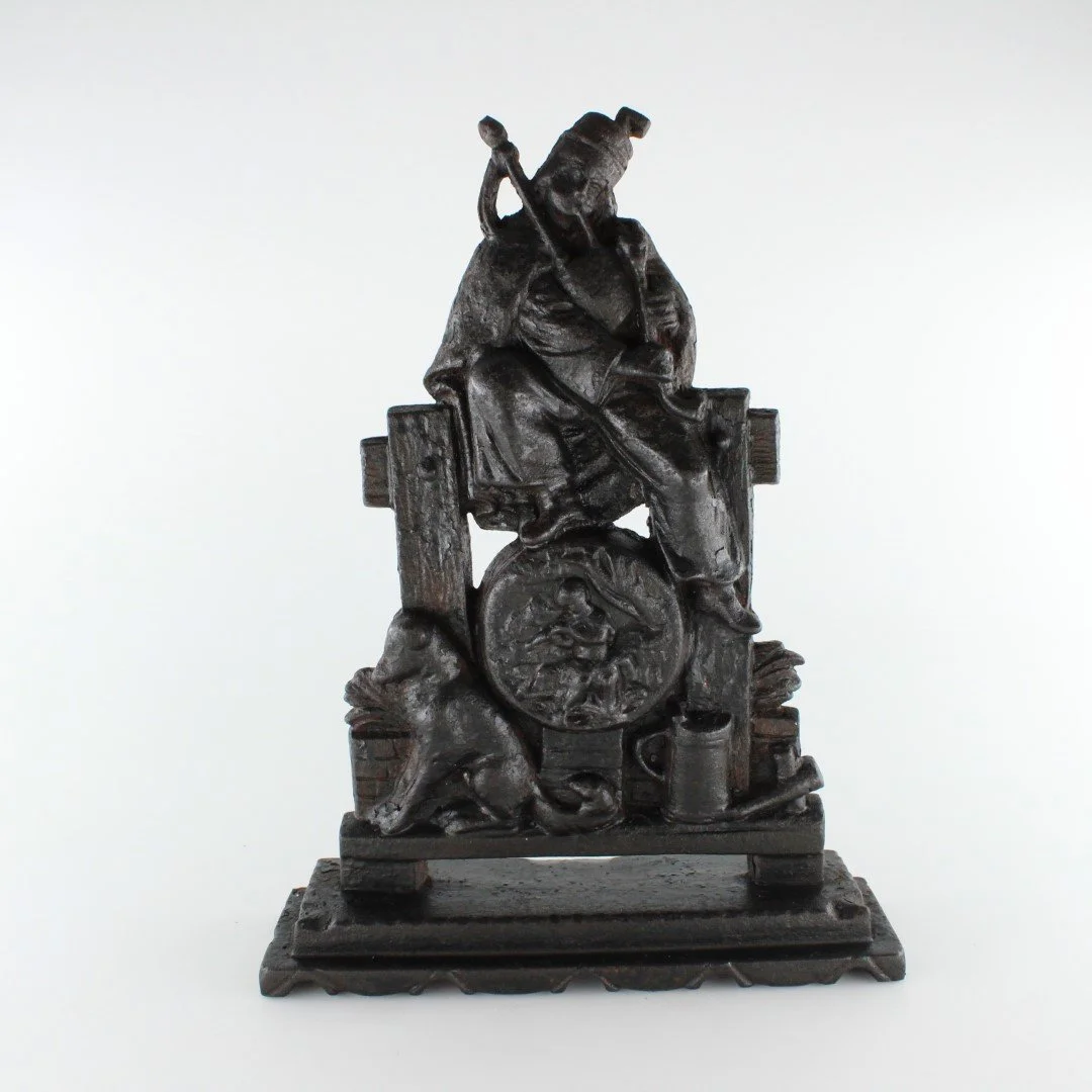 Antique Cast Iron Figural Doorstop – Seated Piper
