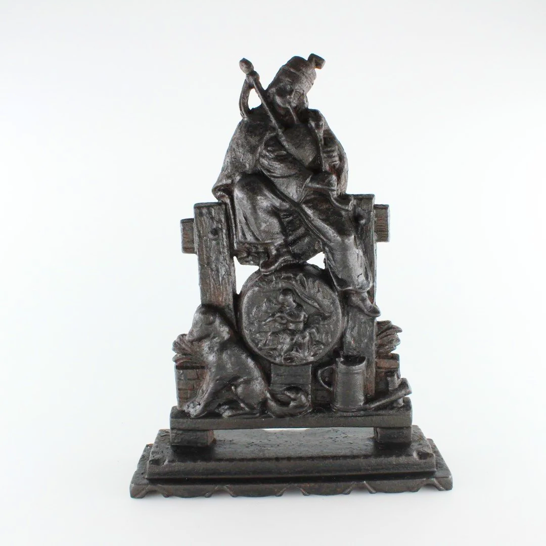 Antique Cast Iron Figural Doorstop – Seated Piper