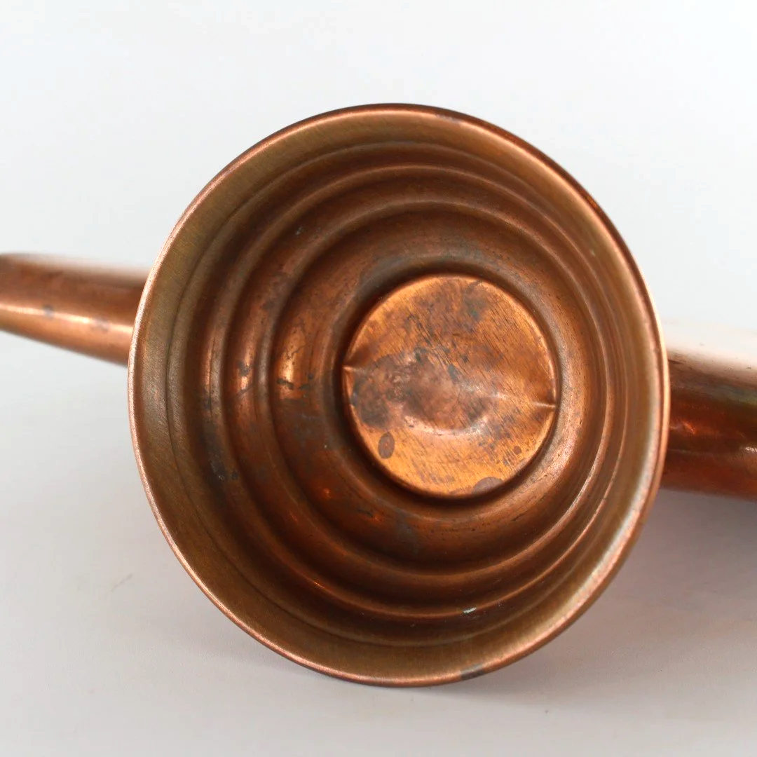 Vintage copper letter rack and mid century modern desk organiser with folded sculptural design and pedestal base against white background.