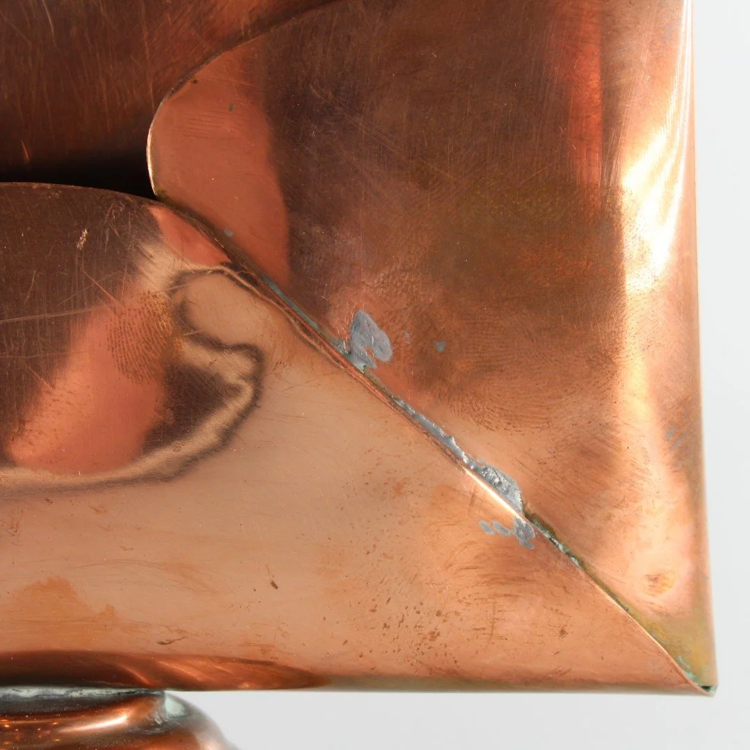 Vintage copper letter rack and mid century modern desk organiser with folded sculptural design and pedestal base against white background.