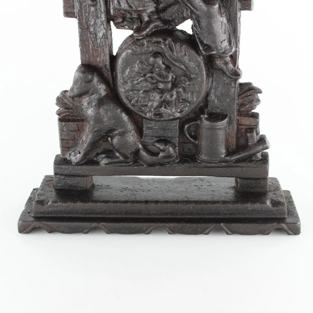 Vintage cast iron figural doorstop depicting seated scholar with decorative relief base