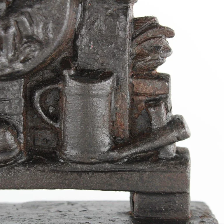 Vintage cast iron figural doorstop depicting seated scholar with decorative relief base