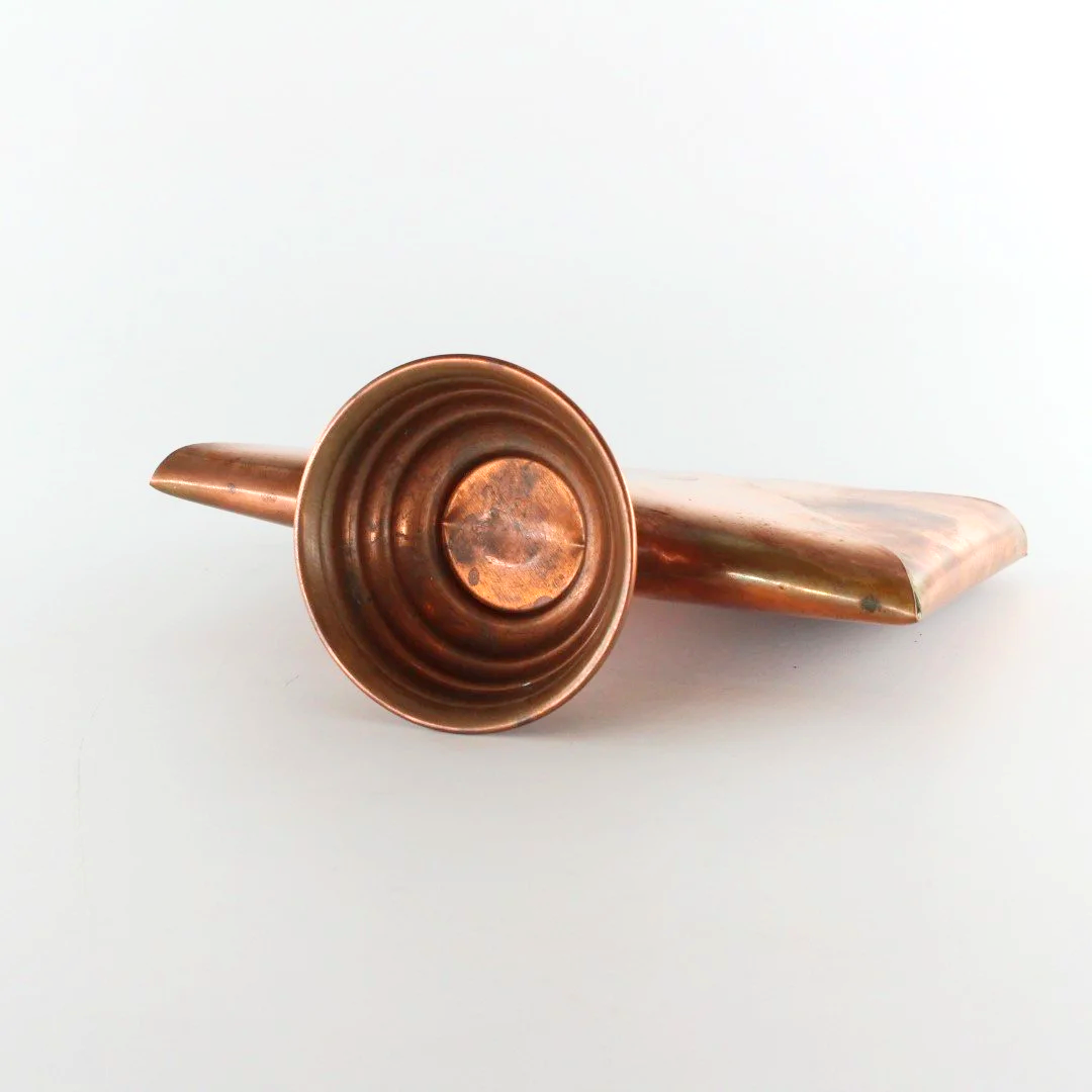 Vintage copper letter rack and mid century modern desk organiser with folded sculptural design and pedestal base against white background.