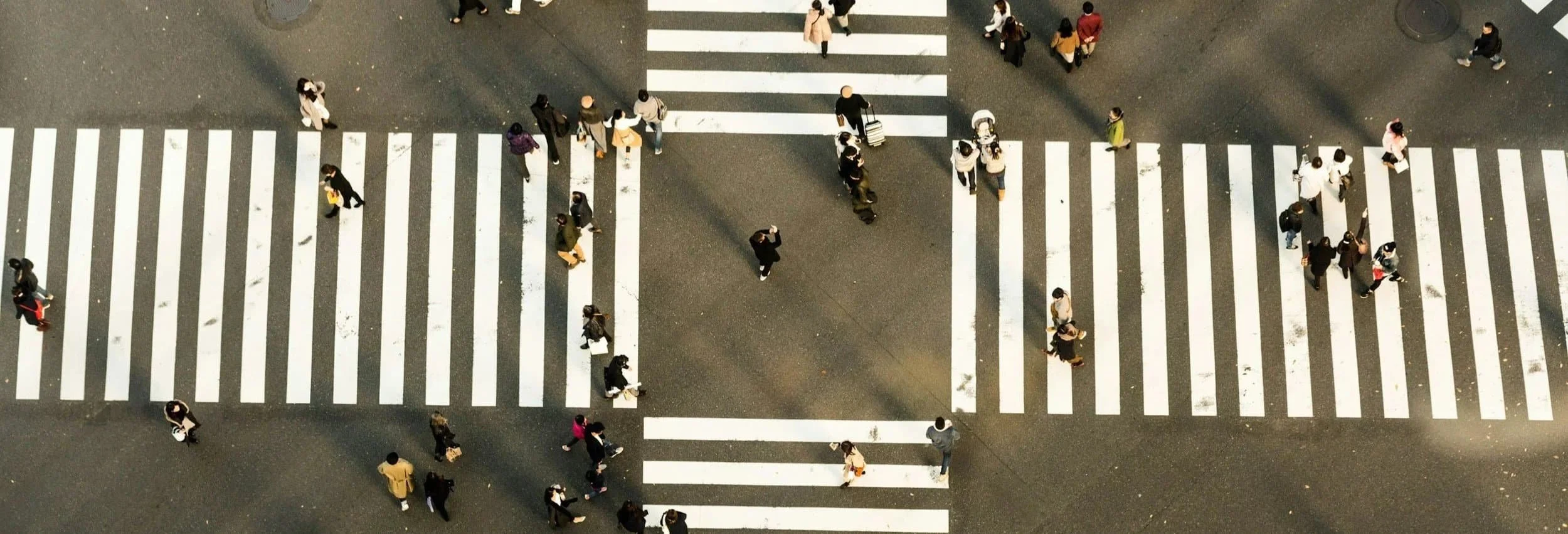 People using a four way pedestrian crossing to cross the road