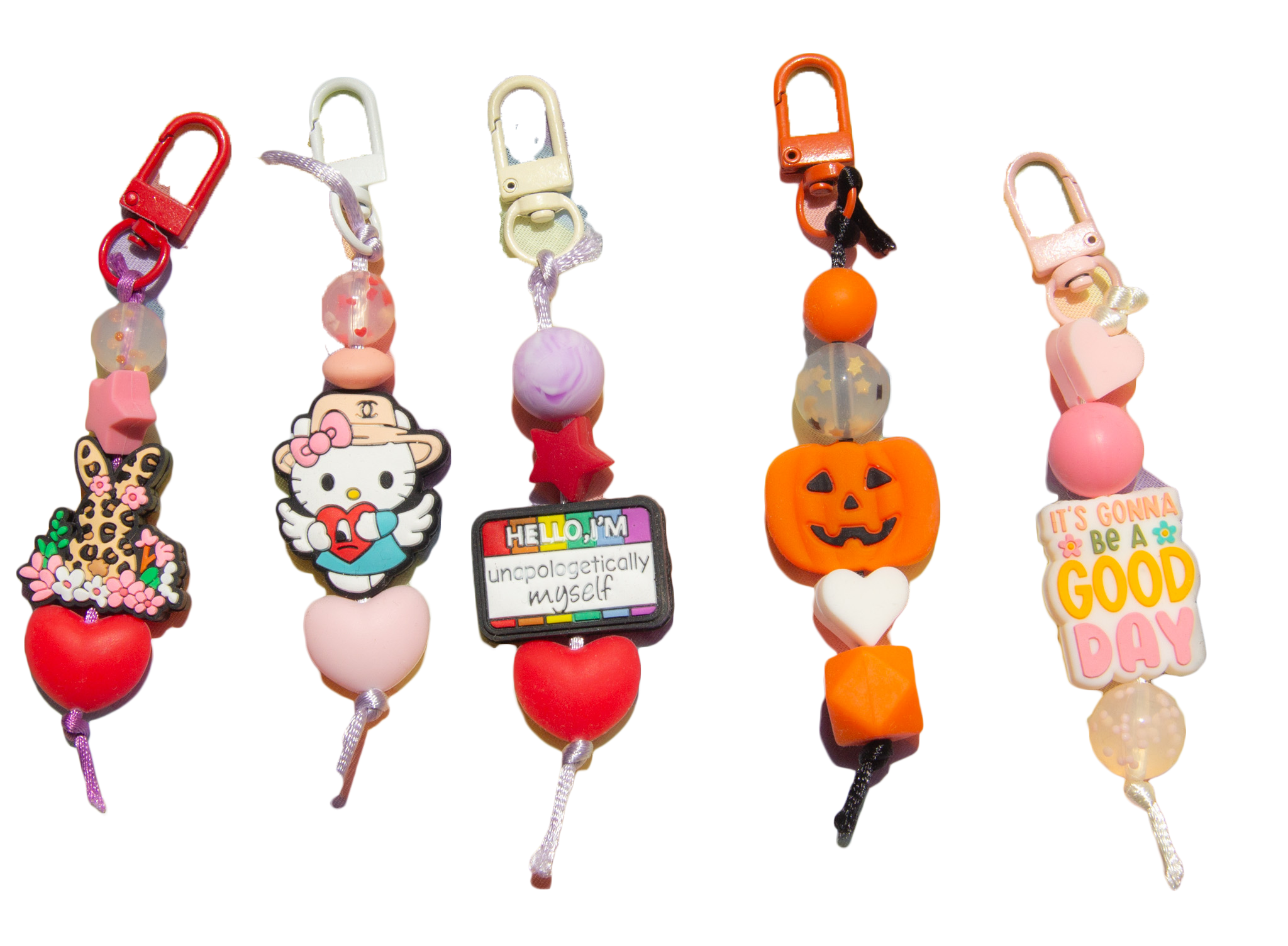 Collection of colorful beaded jewelry with various charms, including a Hello Kitty charm and a pumpkin charm, arranged in a row.