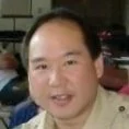 Close-up portrait of a smiling man indoors wearing a beige shirt