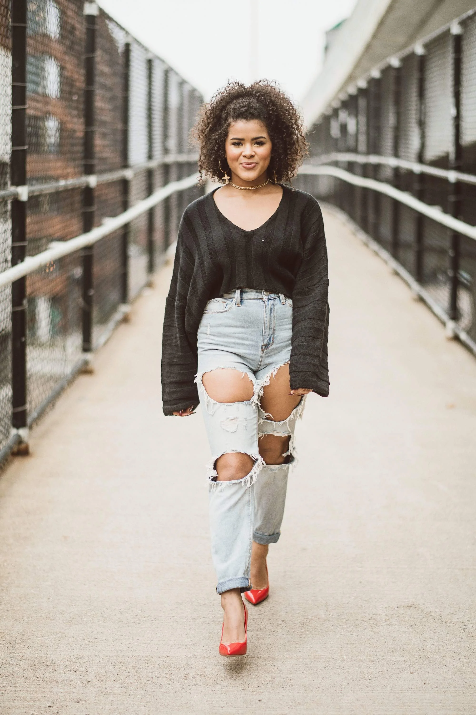Young woman walking down a sidewalk and smiling for her senior photo