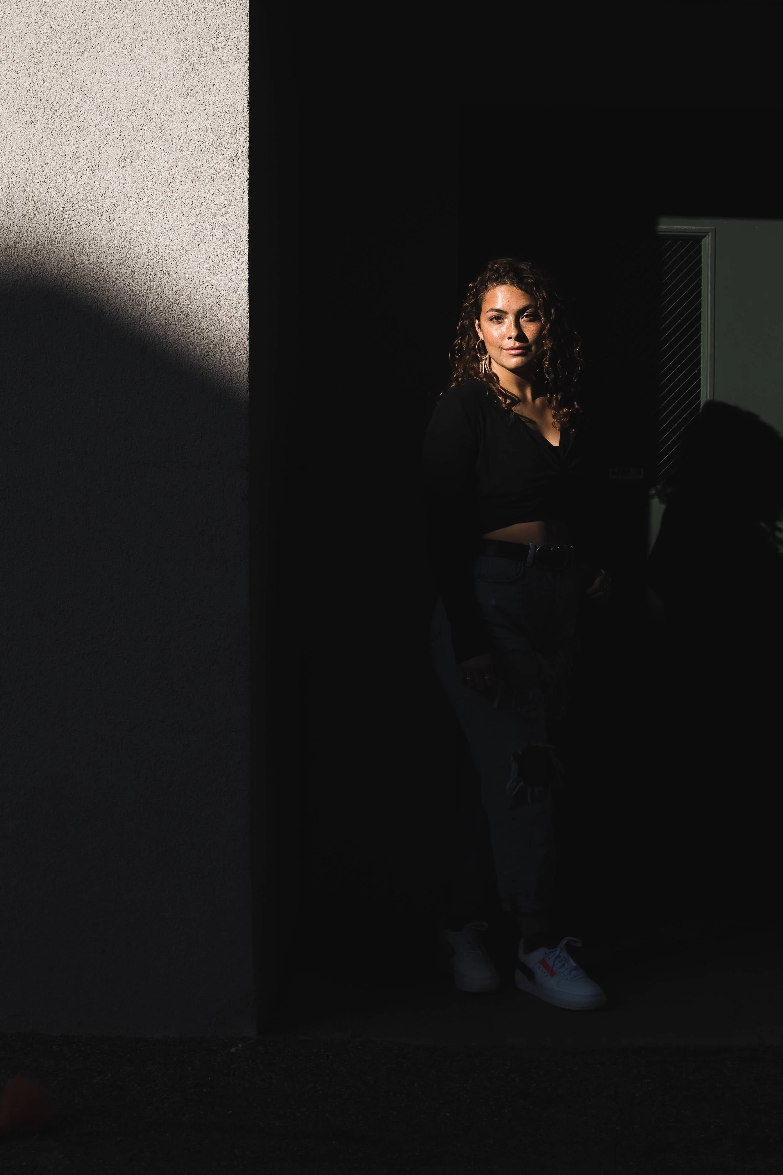 Young woman with a soft smile looking into the camera for her senior photo by Lucas Botz