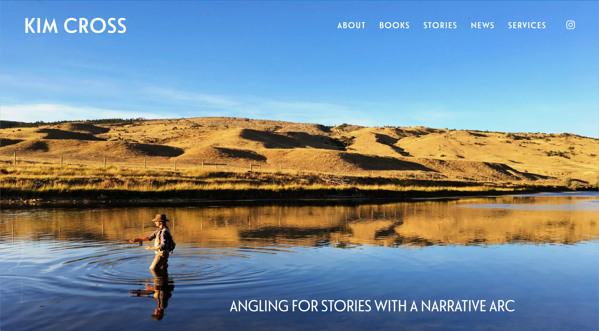 A person fishing in a calm river during sunset with rolling hills in the background.