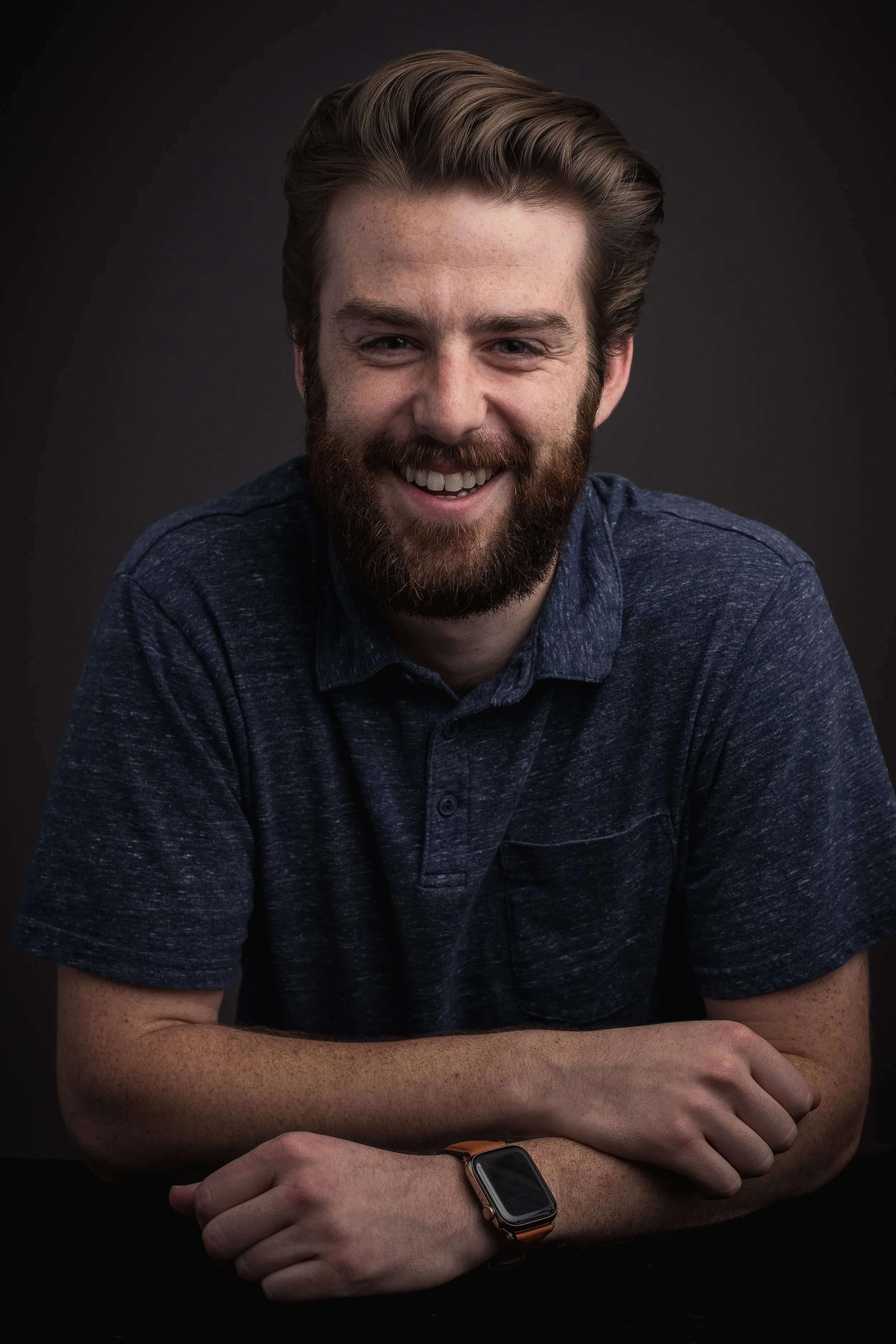 Danny Gray, Director on Permanent Equity's investing team, in a navy polo against a dark gray background.