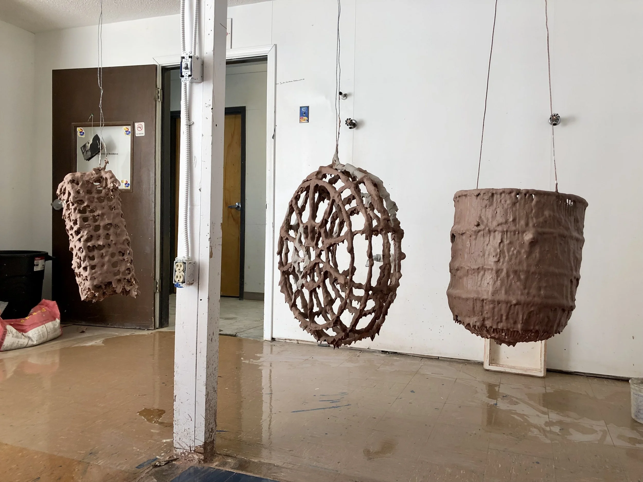 She Who Vomited Out Her Own Metals involved a lot of experimental processes. In this image, you can see that I began hanging steel bird cages from my studio ceiling and coating those cages in layers of ceramic material.