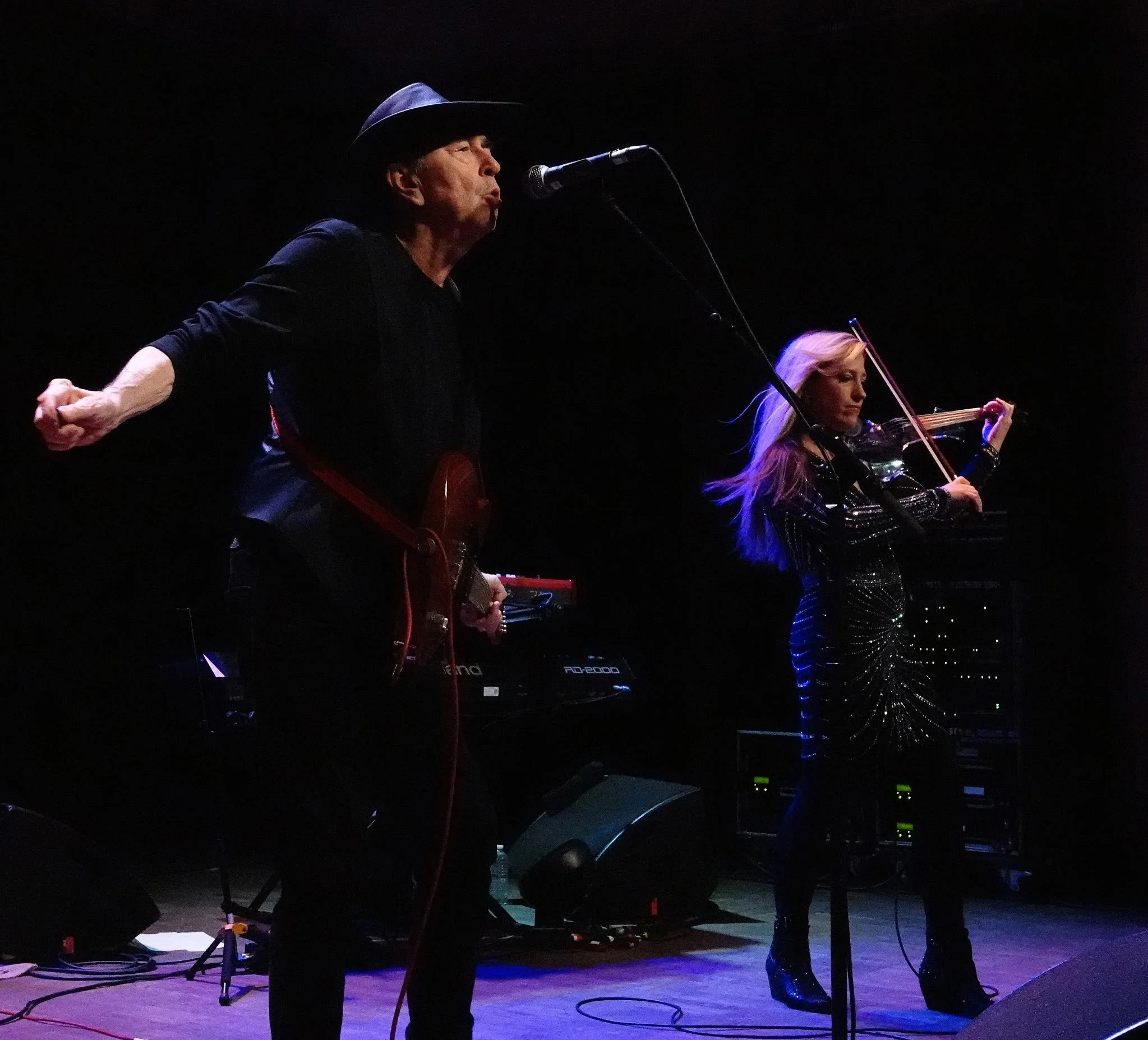 David Surkamp performing with Pavlov’s Dog, arms outstretched on stage.