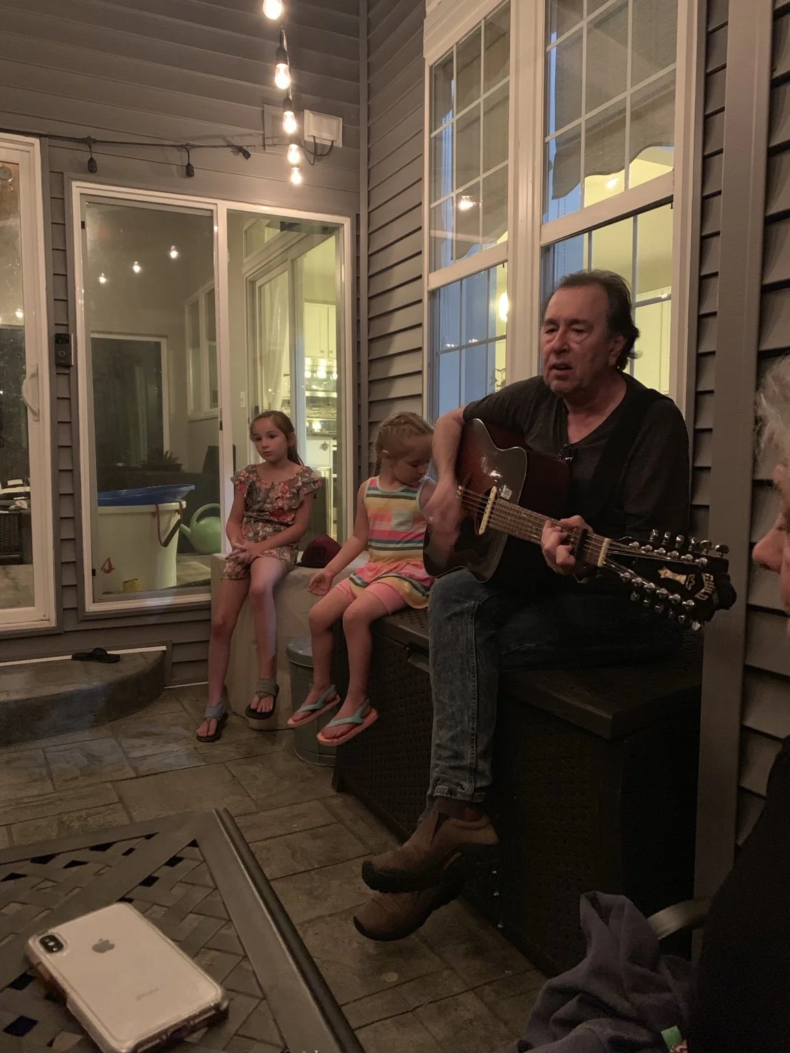 David Surkamp playing acoustic guitar during a gathering.