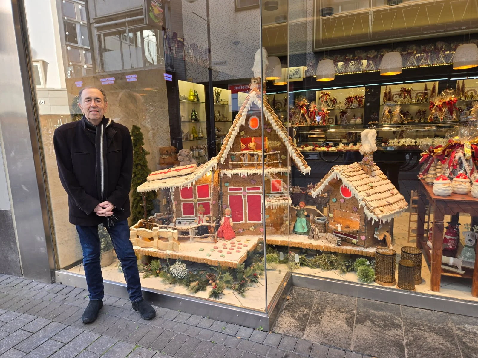 David Surkamp beside a festive shop window while travelling.