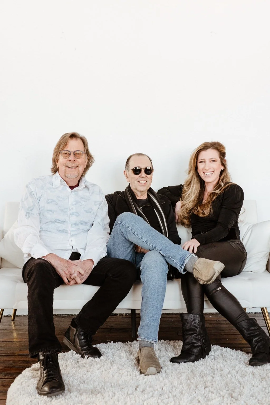 David Surkamp seated with two companions in a studio portrait.