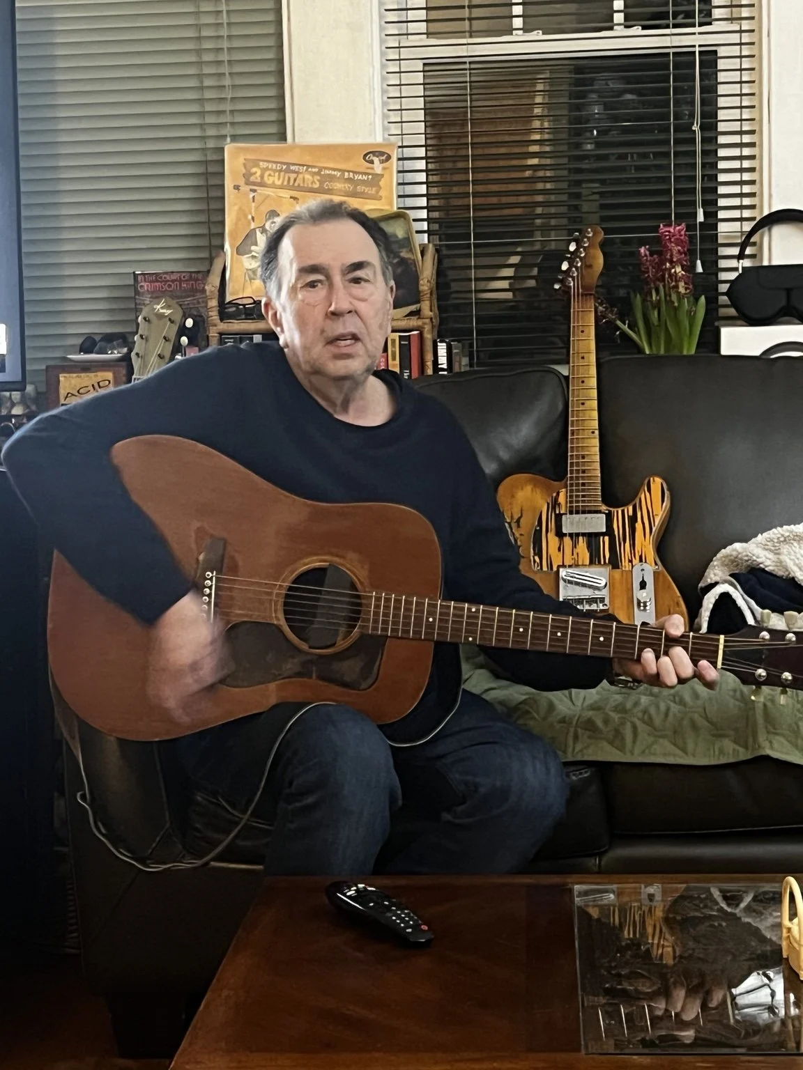 David Surkamp playing acoustic guitar at home.
