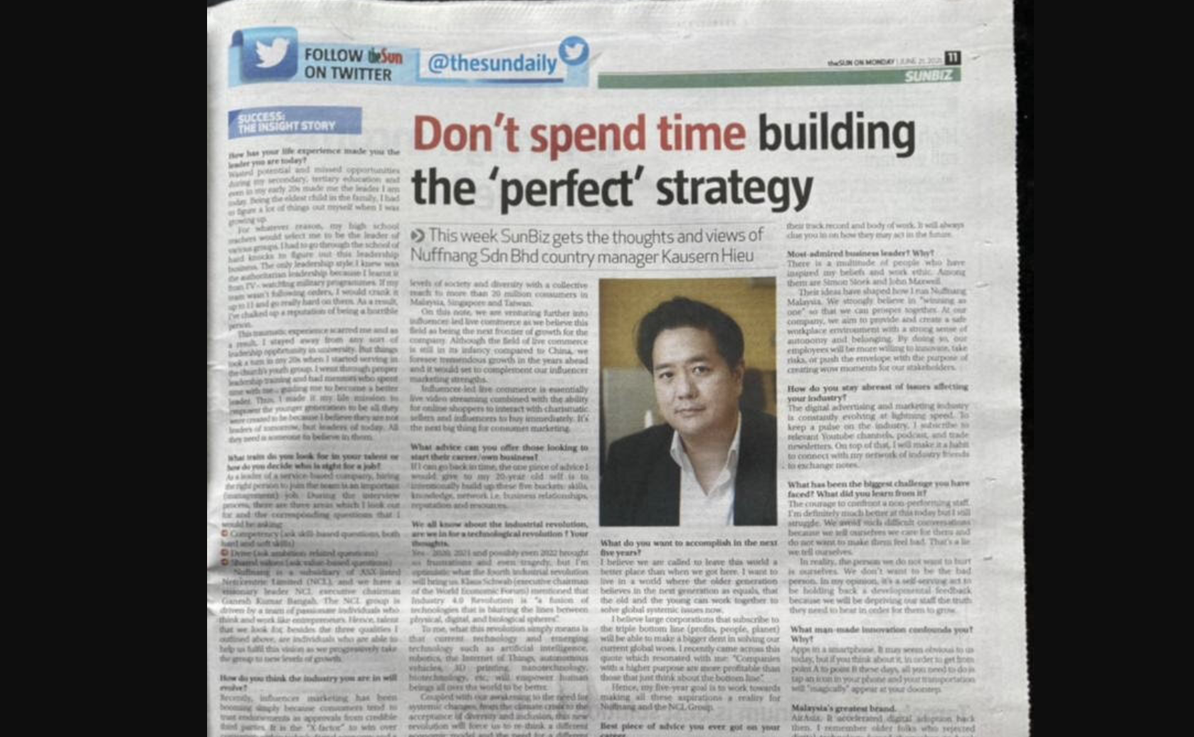 Newspaper article titled 'Don't spend time building the 'perfect' strategy' featuring a photograph of a man and a Twitter handle @thesunday.