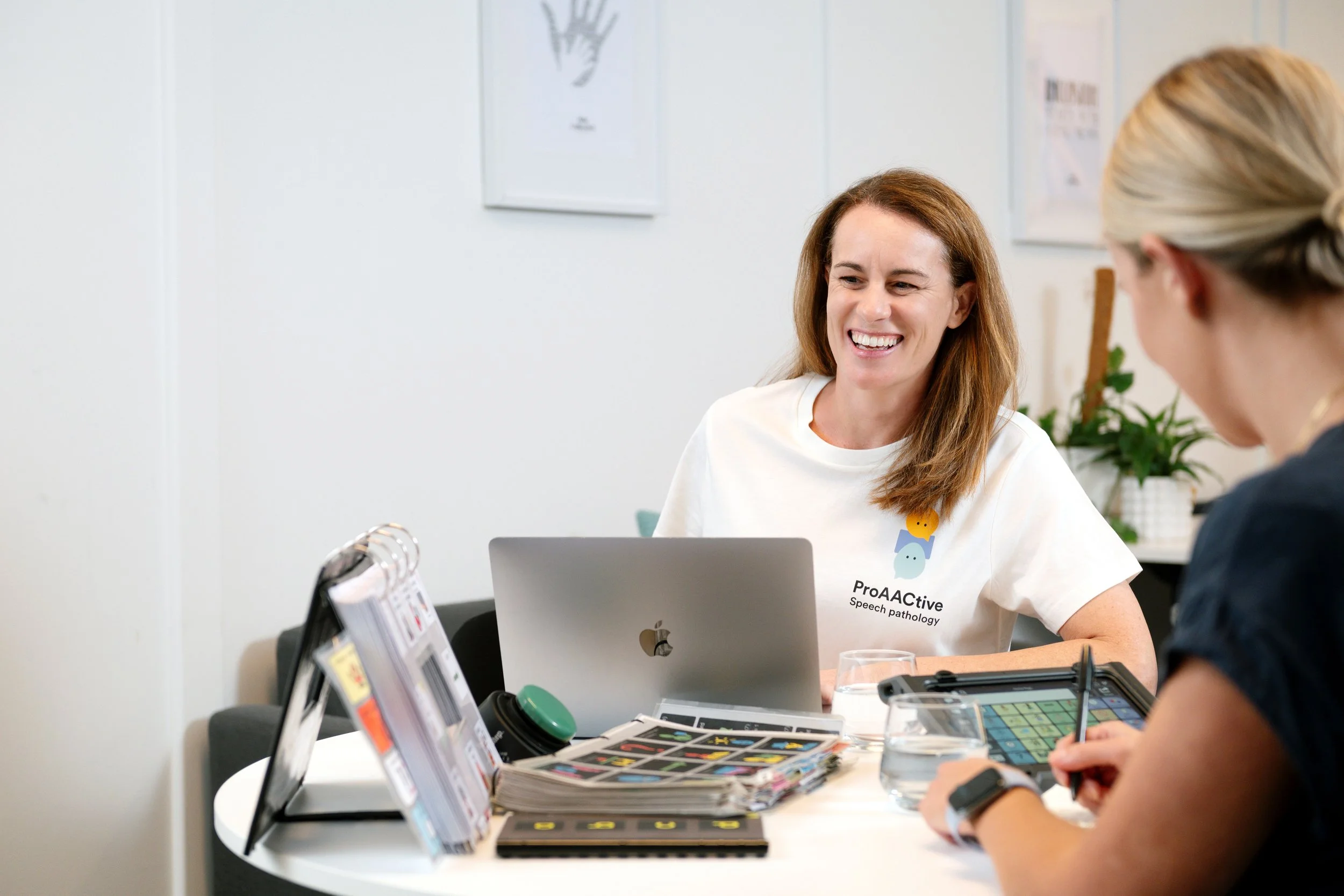 two therapists talking in front of the computer