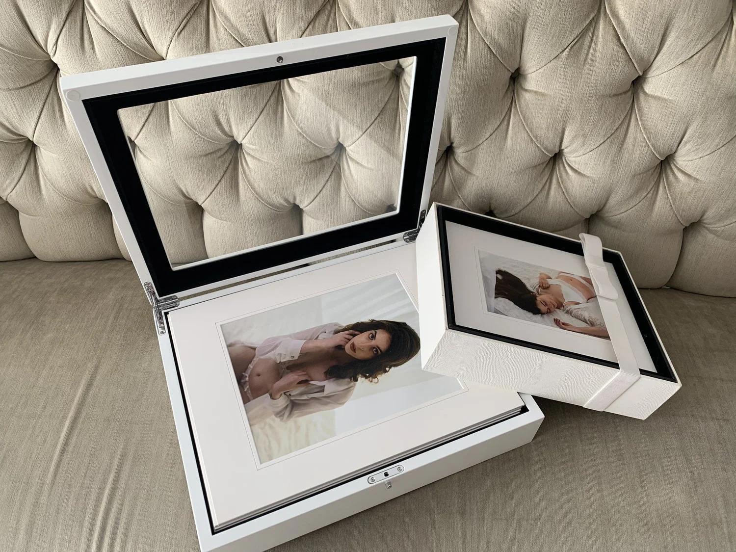 Open white photo storage box containing two framed photographs of women