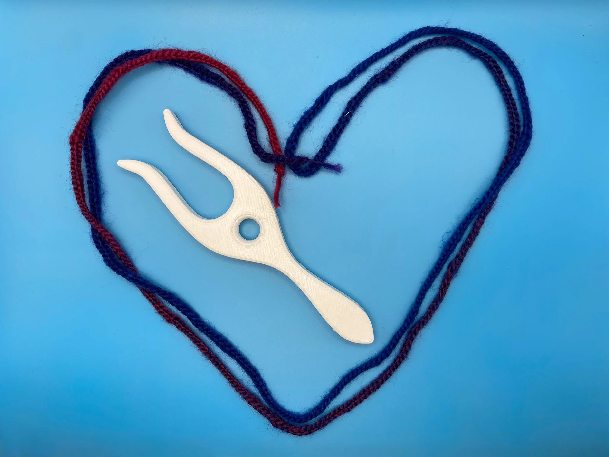 A lucet surrounded by a heart made of the cord created using the lucet