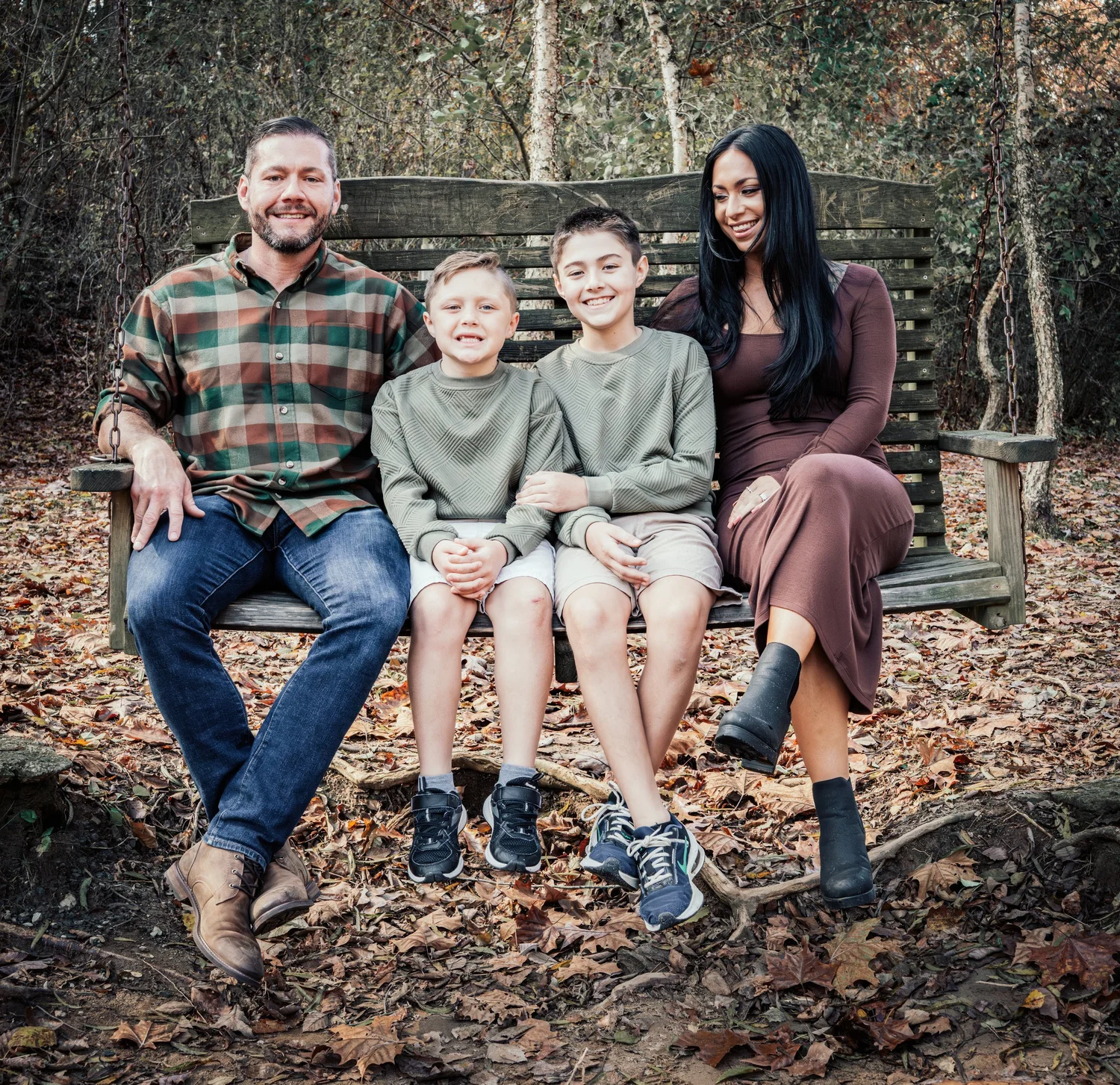 The Grundhoefer family on a wooden bench in the fall woods