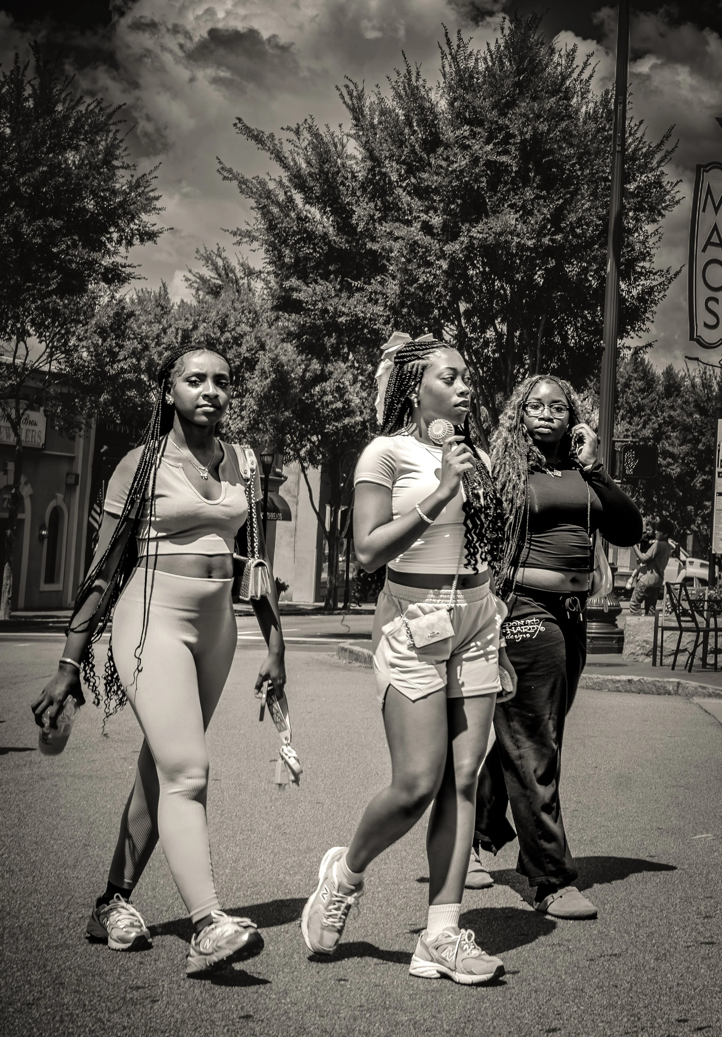 Three women walking outdoors on a sunny day.