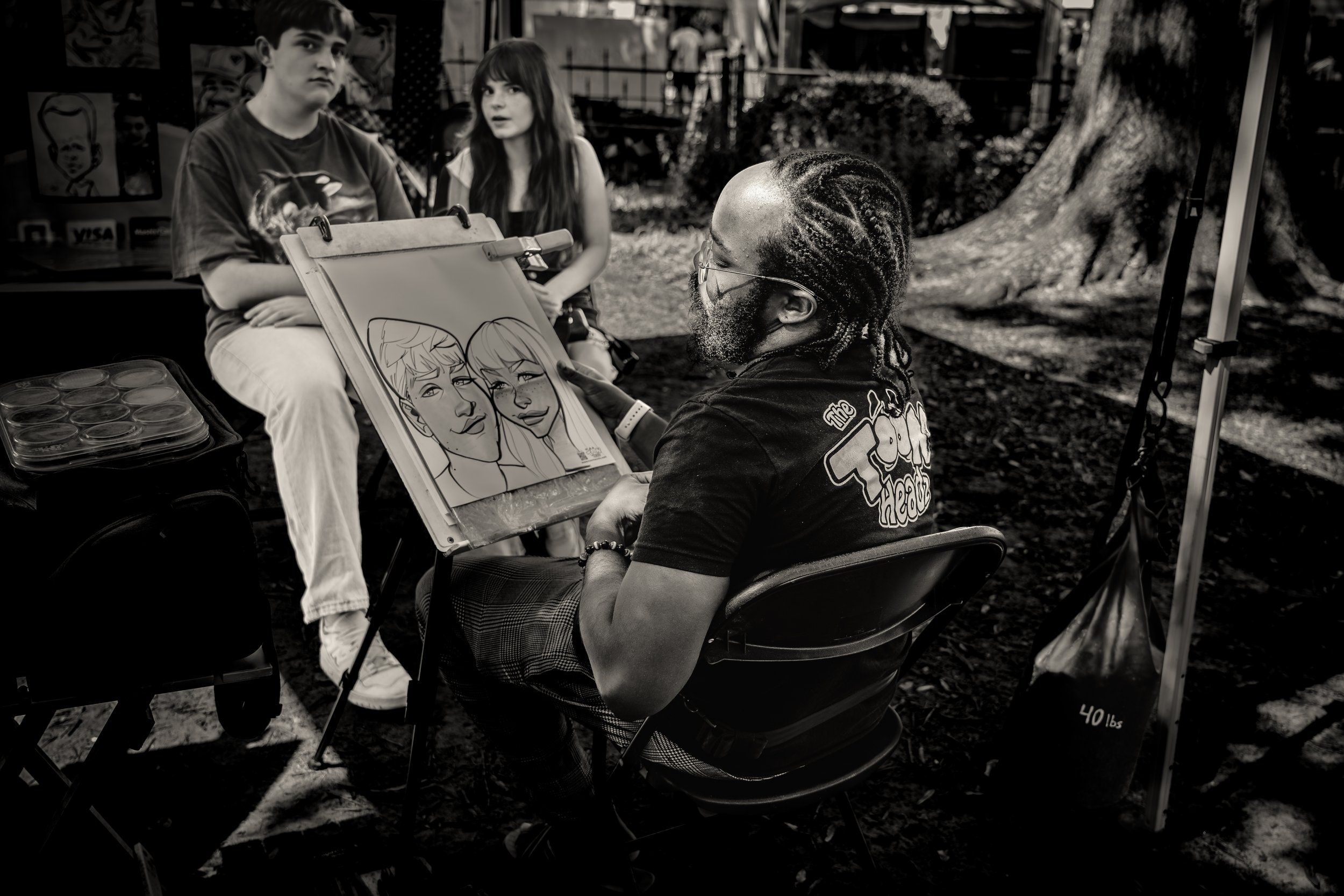 Caricature artist sketching a couple in a park
