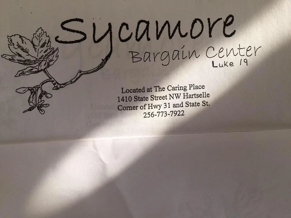 Business card for Sycamore Bargain Center with a hand-drawn sycamore leaf and branch, location details, and phone number.