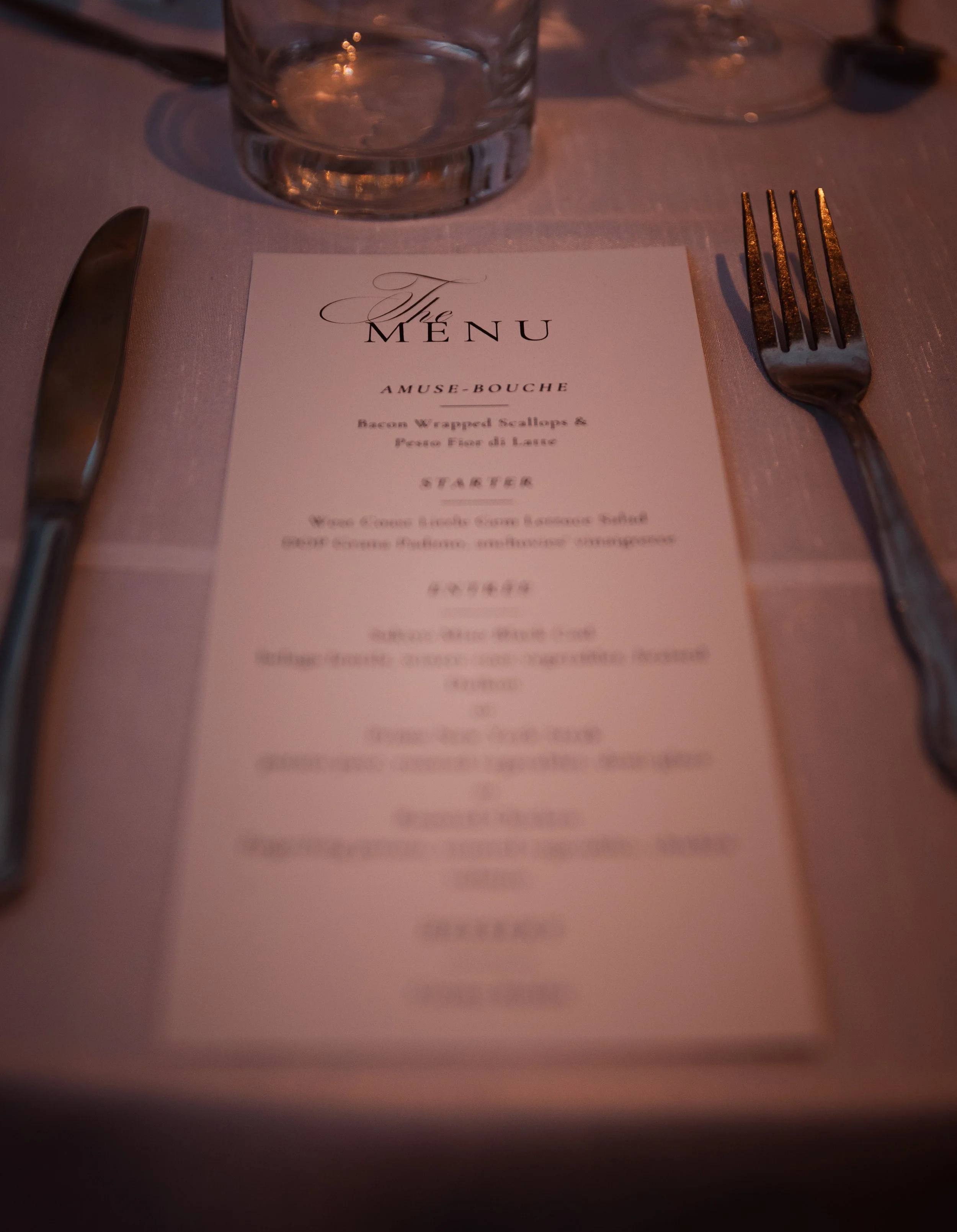 Dinner menu with sections for salads, vegetables, and starch, placed on a white plate with a red napkin tied with twine.