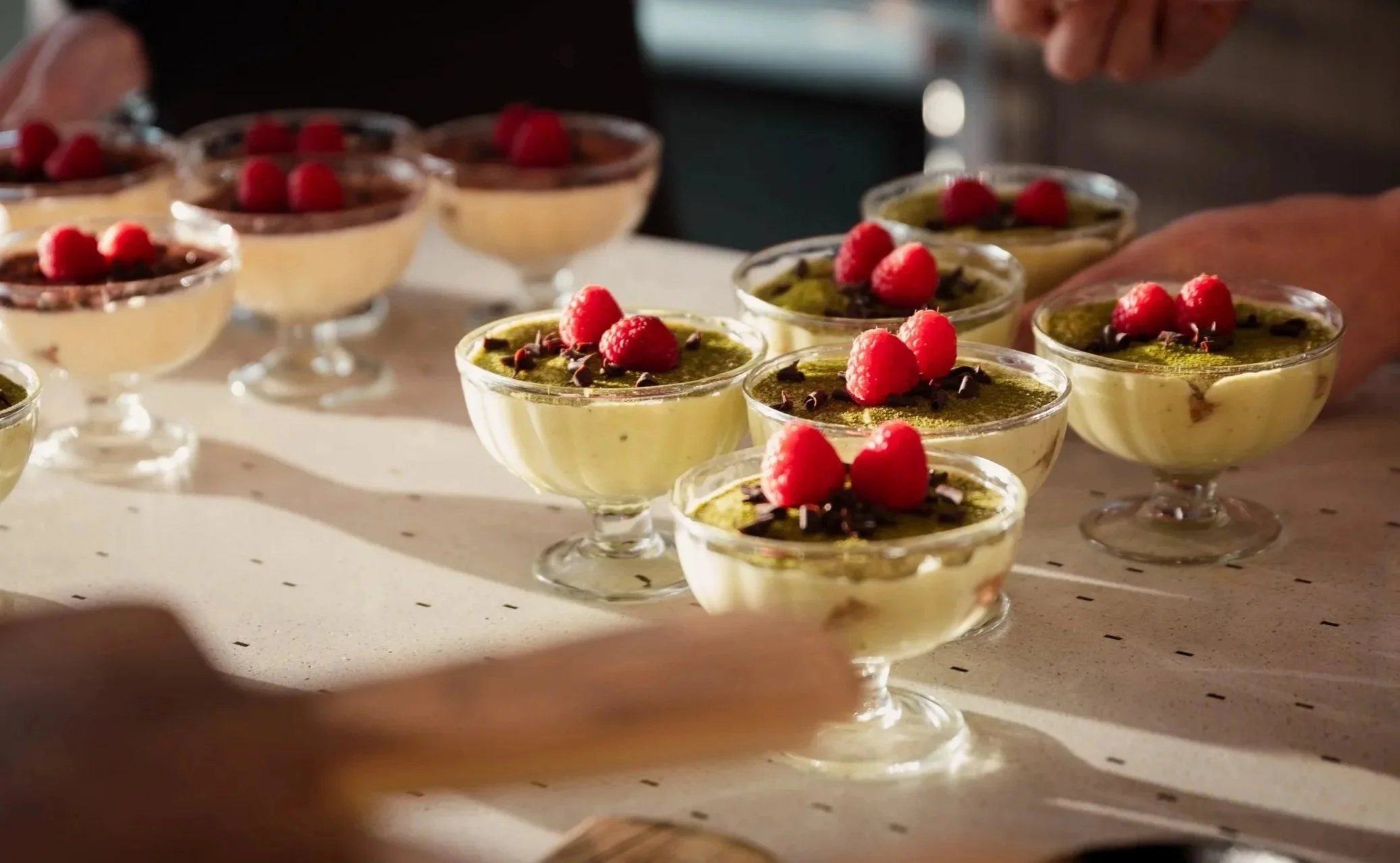 Top view of crème brûlée with a broken caramelized sugar crust, revealing creamy custard inside, and a spoon inserted into the dessert in a white ramekin.