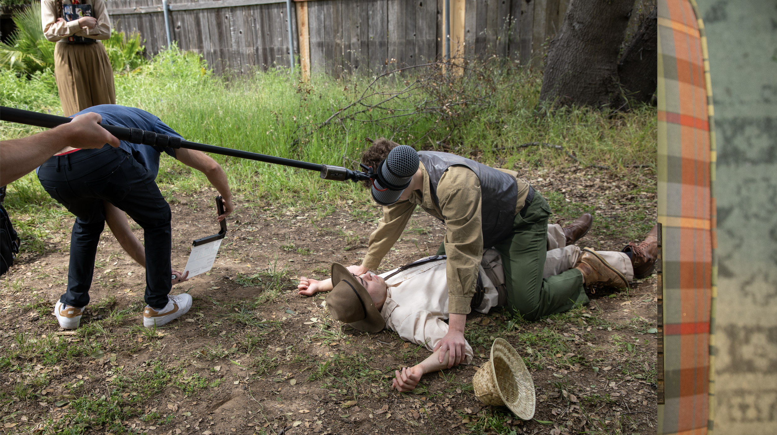 Two actors in safari gear film a fight scene.
