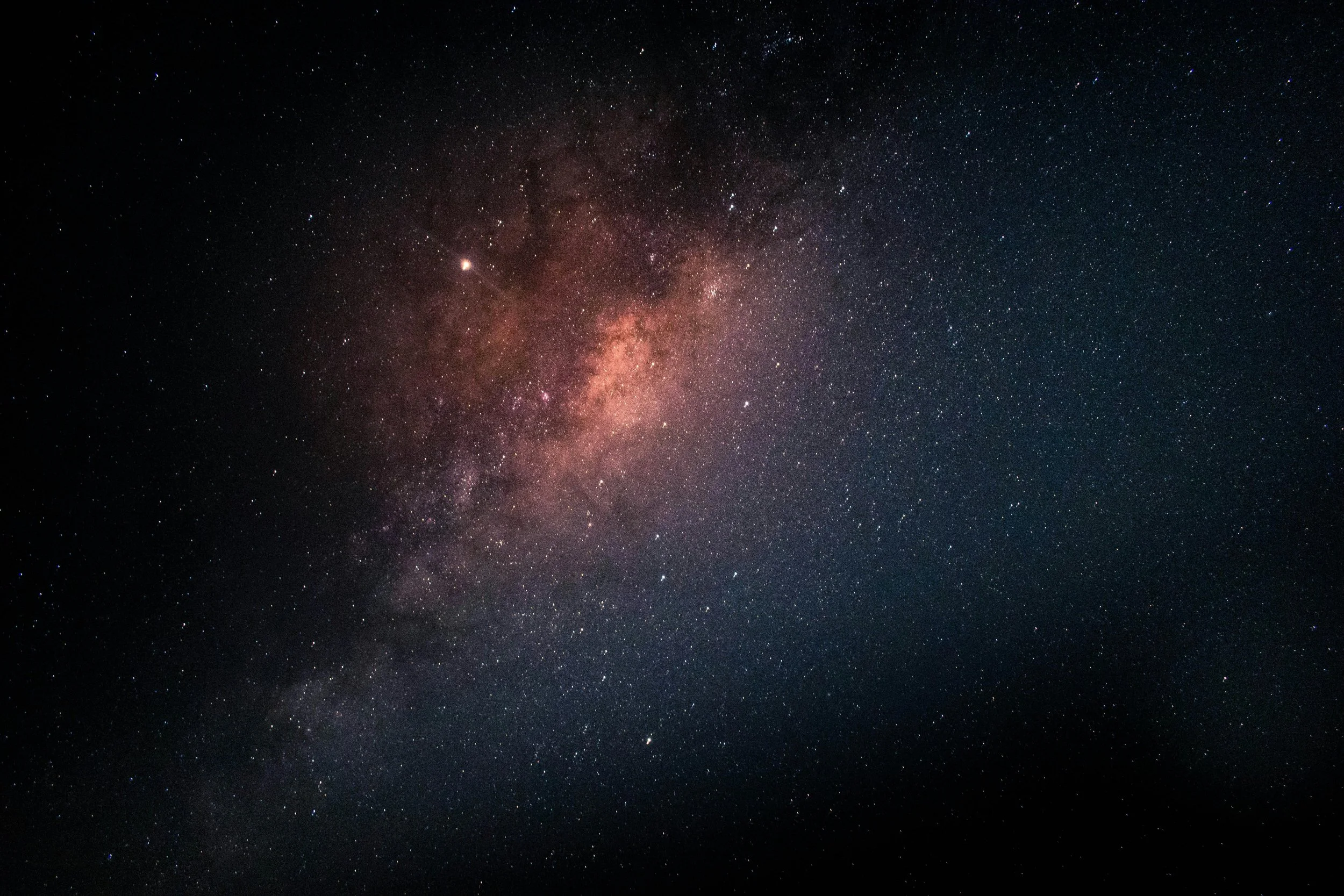 A clear night sky filled with countless stars and the bright core of the Milky Way galaxy.